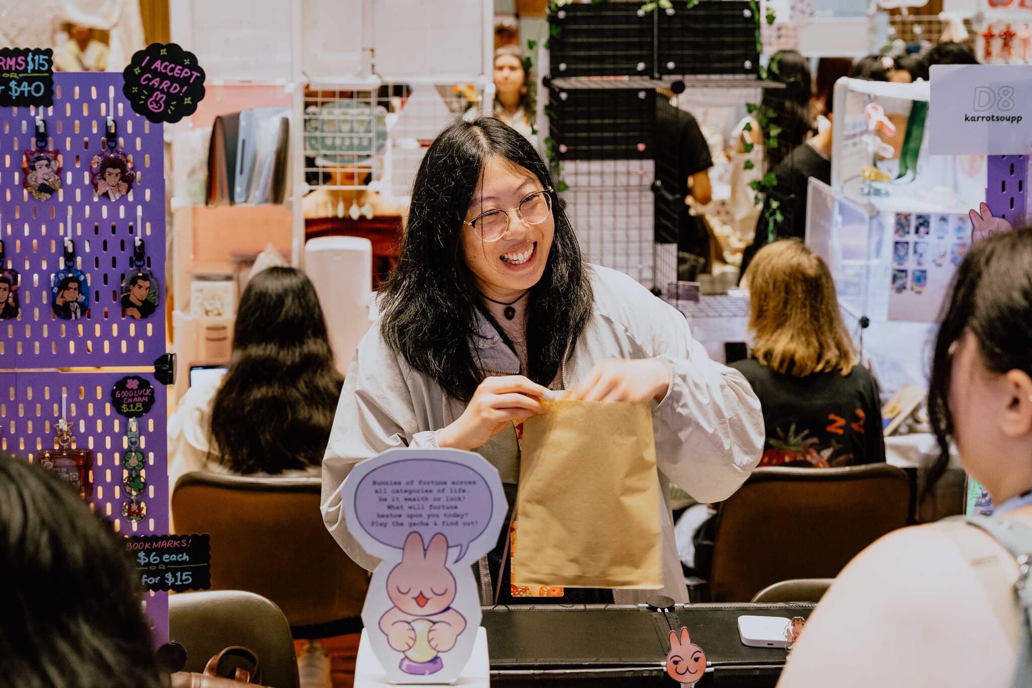 A smiling stallholder handing over a purchase
